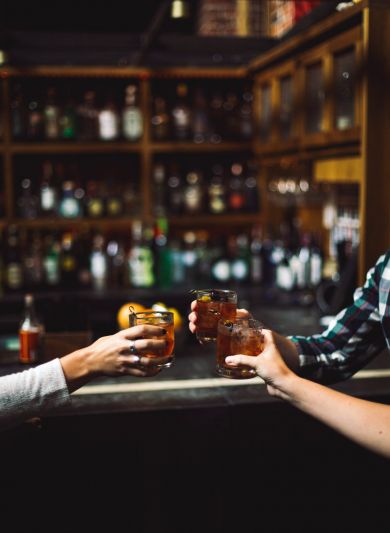 People clinking mixed drinks together in a Nashville bar