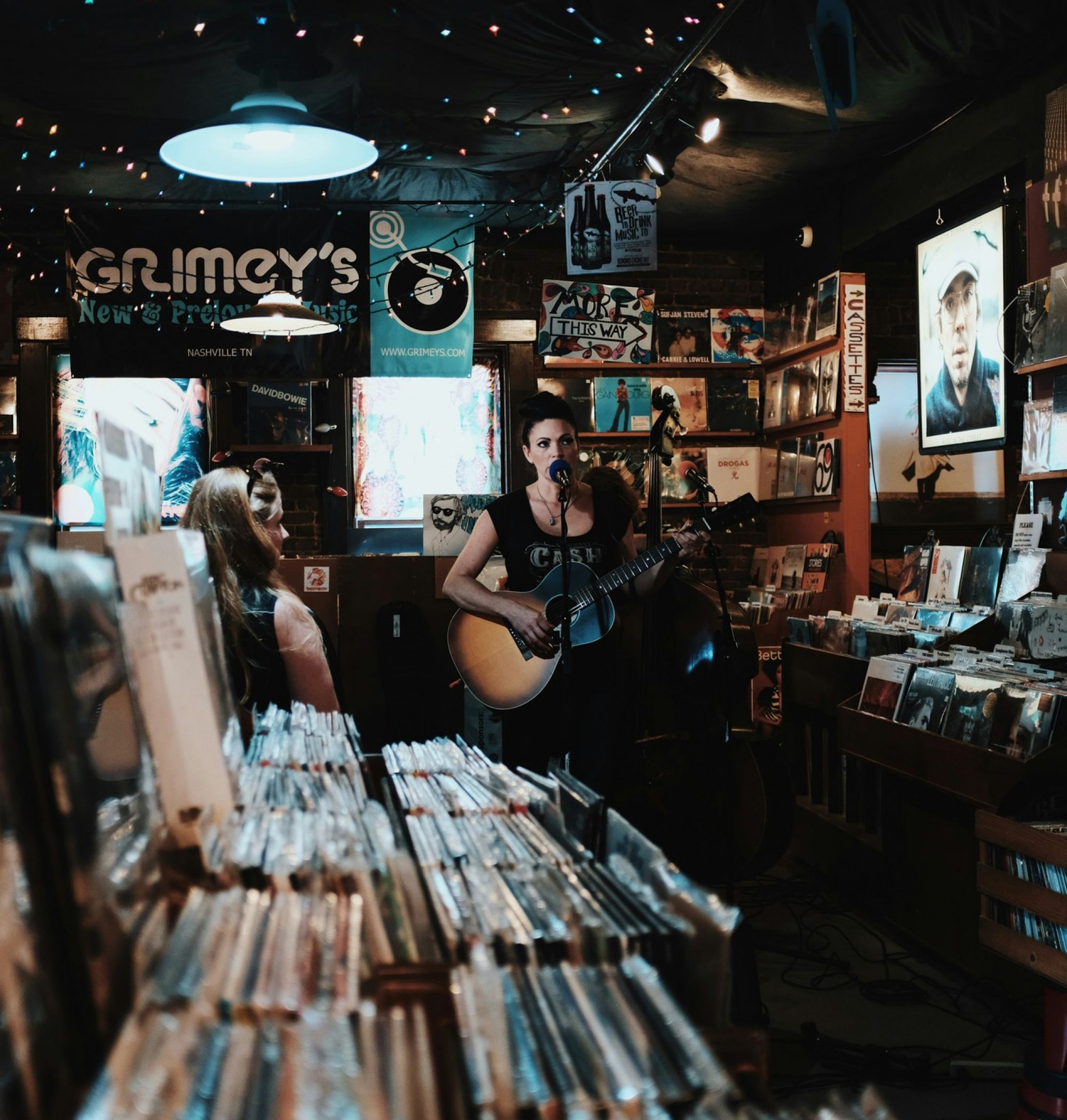 Woman guitarist performing in a vintage record shop in Nashville, TN