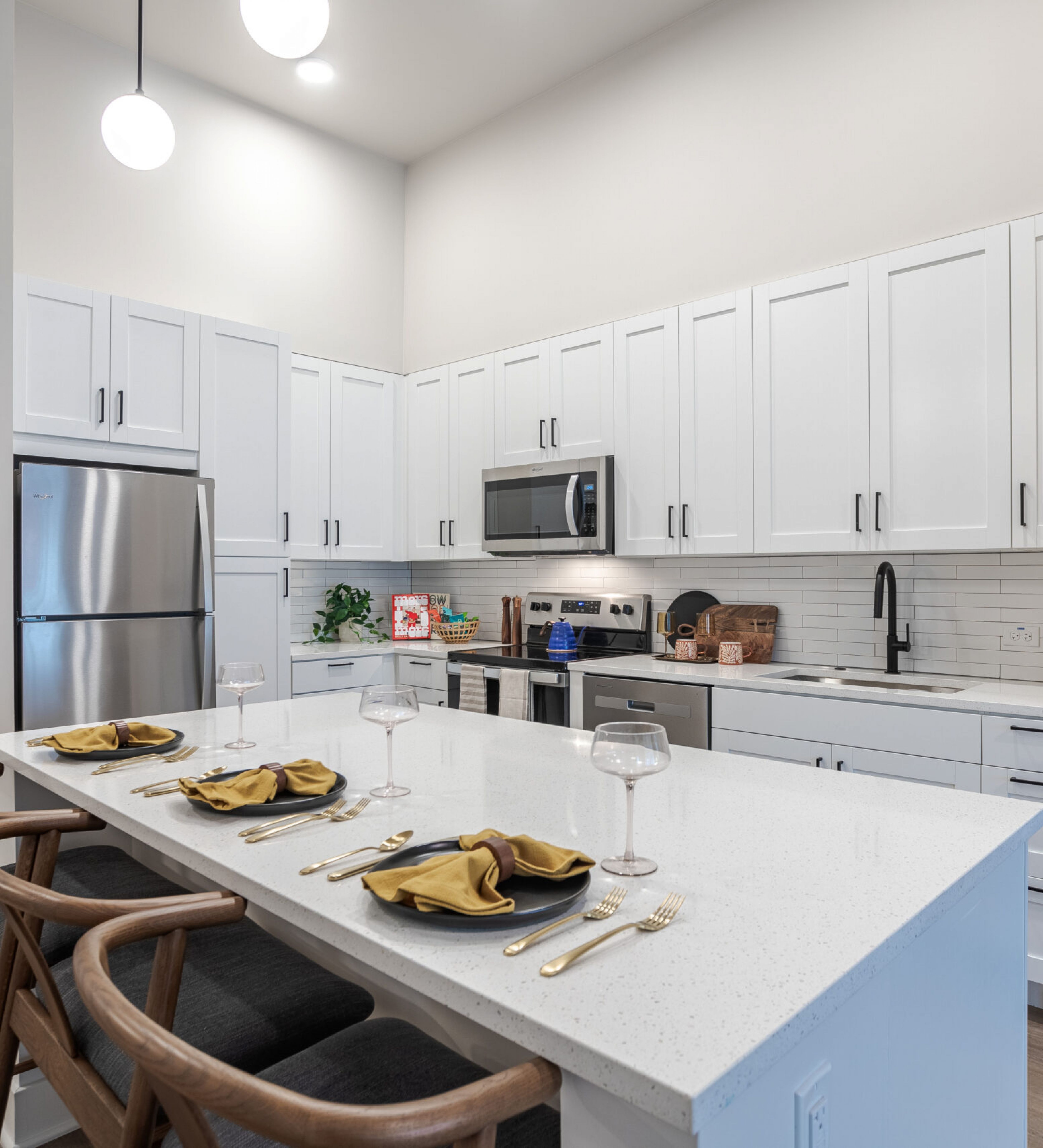 LOCAL Nashville Apartments bright kitchen with white cabinets, stainless steel appliances, and large kitchen island