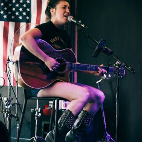 Singer playing guitar wearing cowboy boots in a bar in Nashville, TN