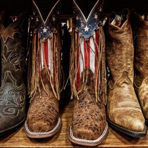 Patriotic and ornate cowboy boots in a row on a shelf