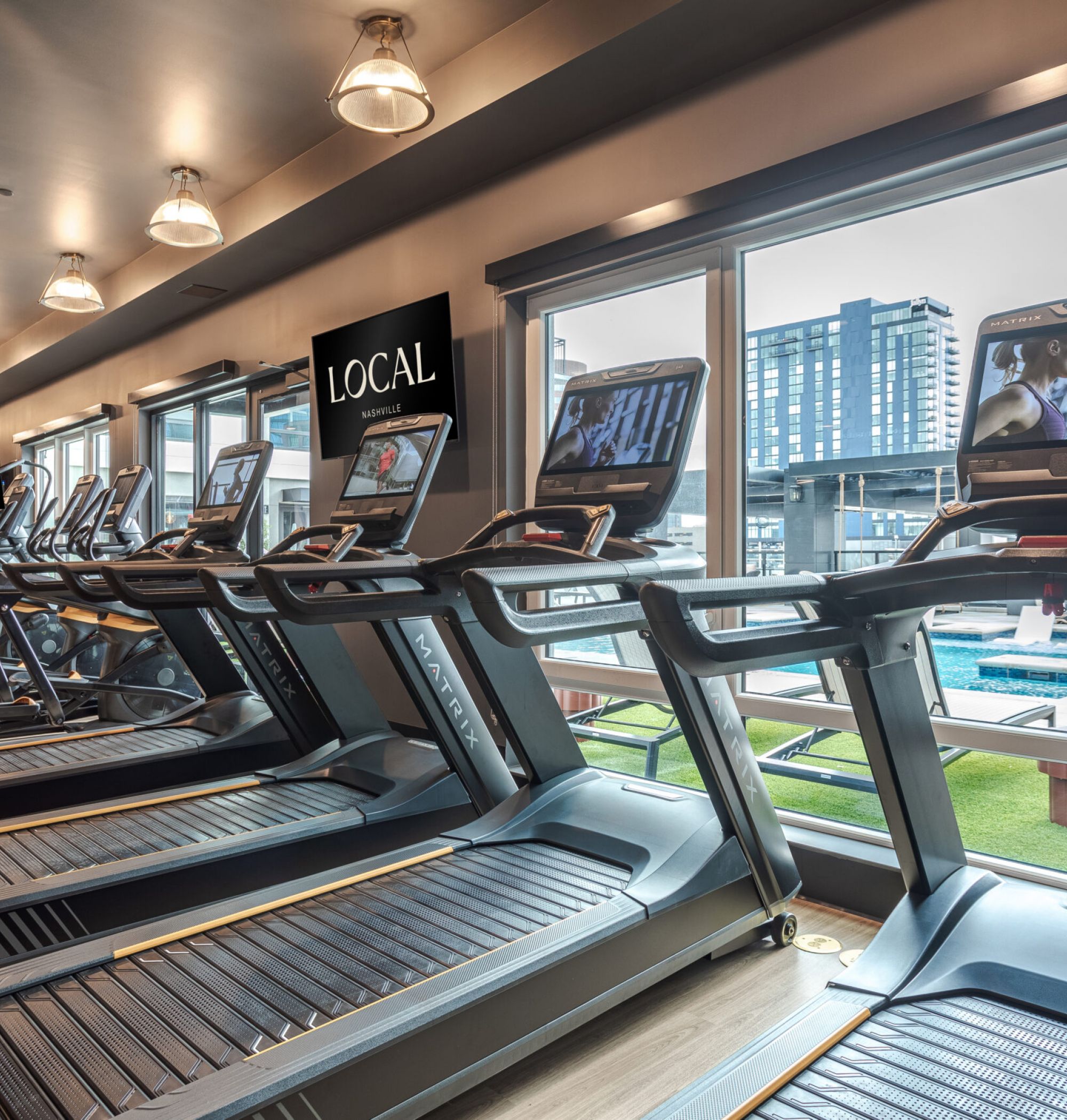 LOCAL Nashville Apartments fitness center rendering with turf flooring, state-of-the-art equipment, and modern lighting