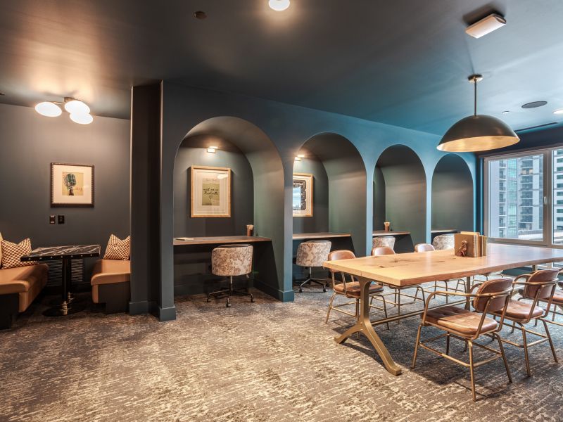 Elegant coworking space with arched alcoves, individual desks, cozy chairs, and a large table under soft lighting.