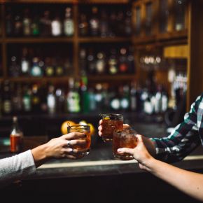 People clinking mixed drinks together in a Nashville bar