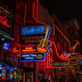 Neon signs lit up at night for restaurants and bars in downtown Nashville, TN