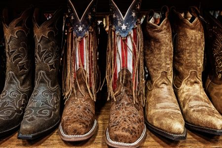 Patriotic and ornate cowboy boots in a row on a shelf