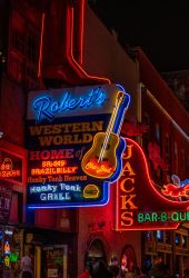 Neon signs lit up at night for restaurants and bars in downtown Nashville, TN