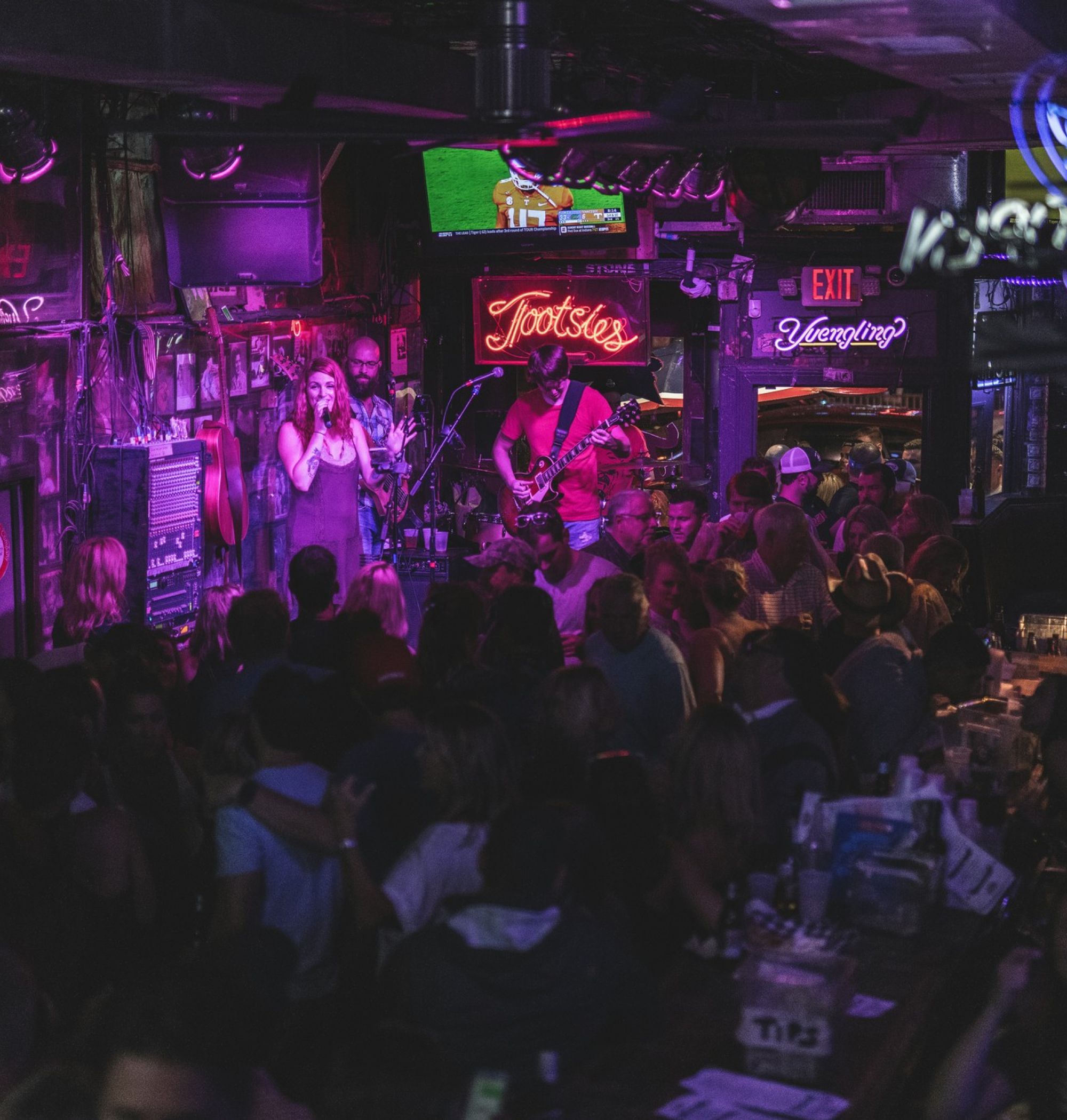 Live band performing in a dark, crowded dive bar in downtown Nashville, TN